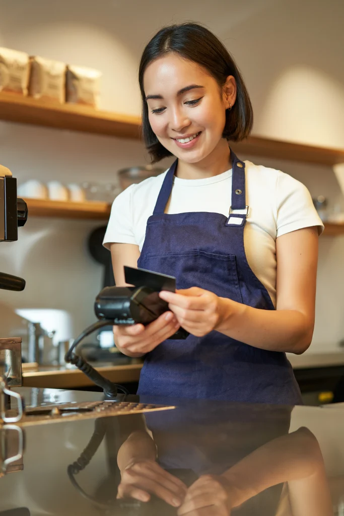 Portrait of a beautiful Asian entrepreneur processing a credit card